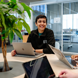 A Swansea University students sitting at a desk with a laptop.