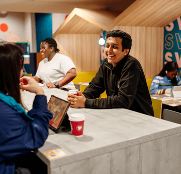 Myfyrwyr yn sgwrsio yn y man cymdeithasol cudd