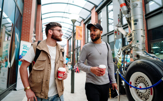 Two students talking and walking on Bay Campus 