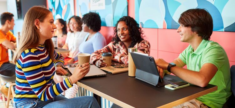 Three people sat at a desk with laptops